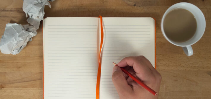 Escritor escrevendo no caderno em branco