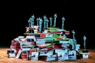 Estátuas do prêmio Açorianos sobre pilha de livros
