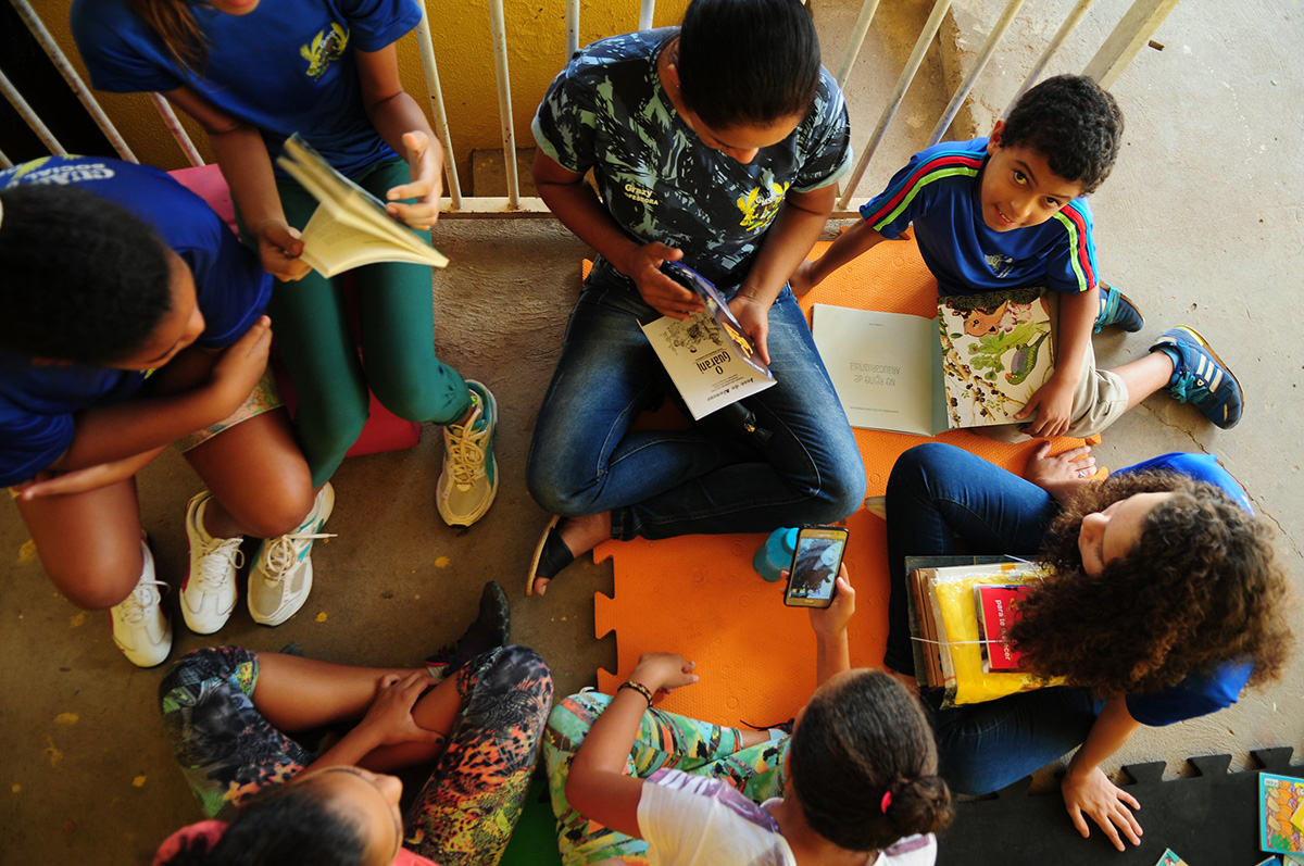 Roda de pré-adolescentes lendo livros