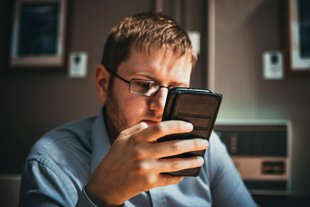 Pessoa de óculos lendo no celular