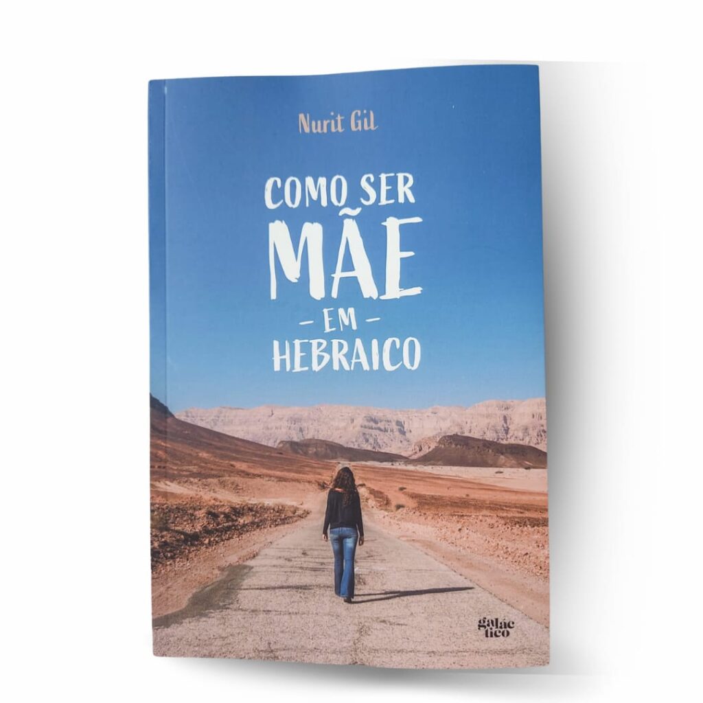 Capa do livro Como ser mãe em hebraico. A imagem tem montanhas ao fundo e numa estrada, de costas, uma mulher caminha em direção às montanhas